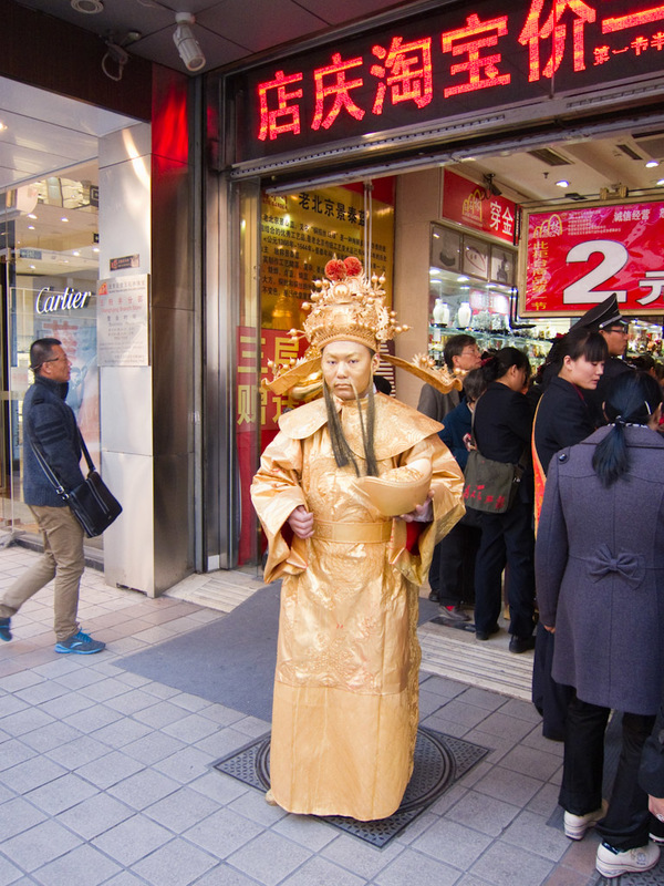 China-Beijing-Tiananmen Square - Many stores have some sort of gimmick out the front, I have seen Darth Vader, a knight in shining armour, geishas and this guy.