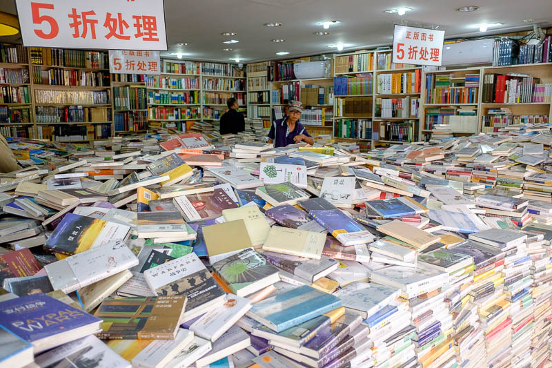 The great loop of China - April 2018 - Here is a Chinese bookshop. A truck backs up and pours books out. They must be presented this way by law, in the centre of each pile is a bundle of pe