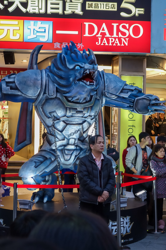 Taiwan-Taipei-Ximending-Shopping Street - Theres a huge crowd, except by this guy under the werewolf. He stands alone.