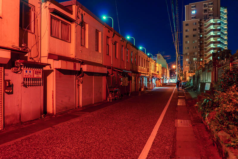 Of course I am back in Japan yet again - Oct and Nov 2018 - Near the drain was this row of shops and houses, with strange colored lighting. It was over the road from a huge graveyard, perhaps the red lights are