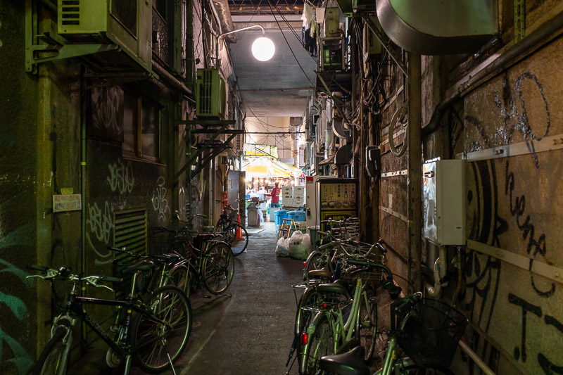 Japan-Tokyo-Ueno-Curry - Here are some bikes, some pipes, and a guy lit up by bright lights. Thats a new form of Haiku. Guy at the end of the alley was yelling loudly to himse