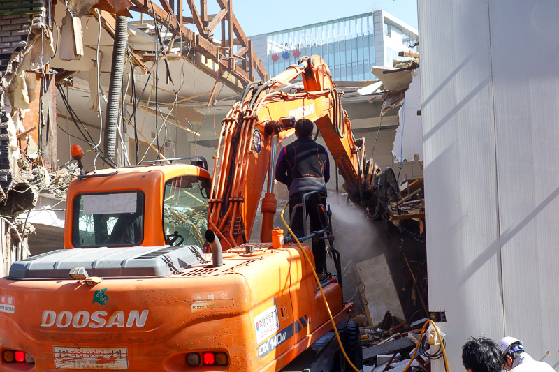 Korea-Seoul-Gangnam-Insadong-Mall - I kept my camera poised on this scene for 10 minutes. I was certain this would end badly. Look closely, the guy standing on the backhoe which is eatin