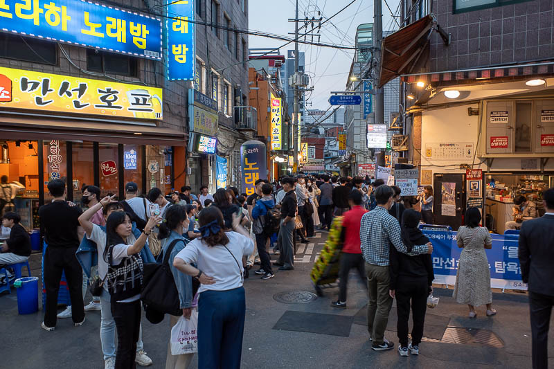 Korea for the 4th time - May and June 2022 - Back in Myeongdong, and it is very busy. Too busy to even walk through. I had to do a retreat to somewhere less busy. Also the guy playing the guitar 