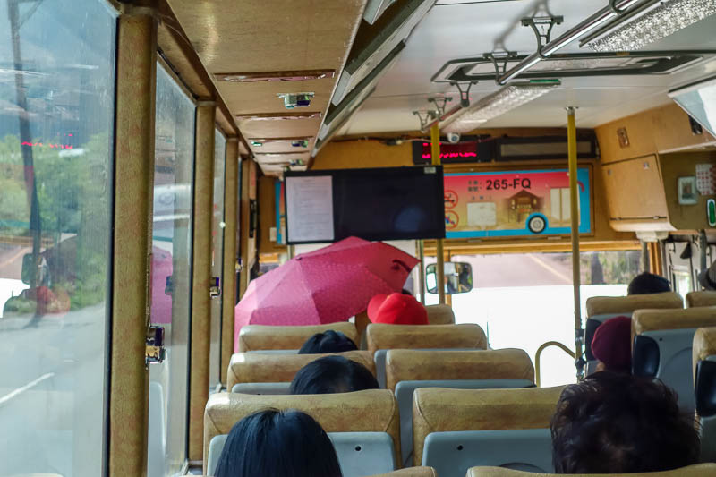 A full lap of Taiwan in March 2017 - Boring photo from inside the bus to Jiufen, or is it? Note the woman up the front has put her umbrella up, inside the bus. Another new way to terrify 